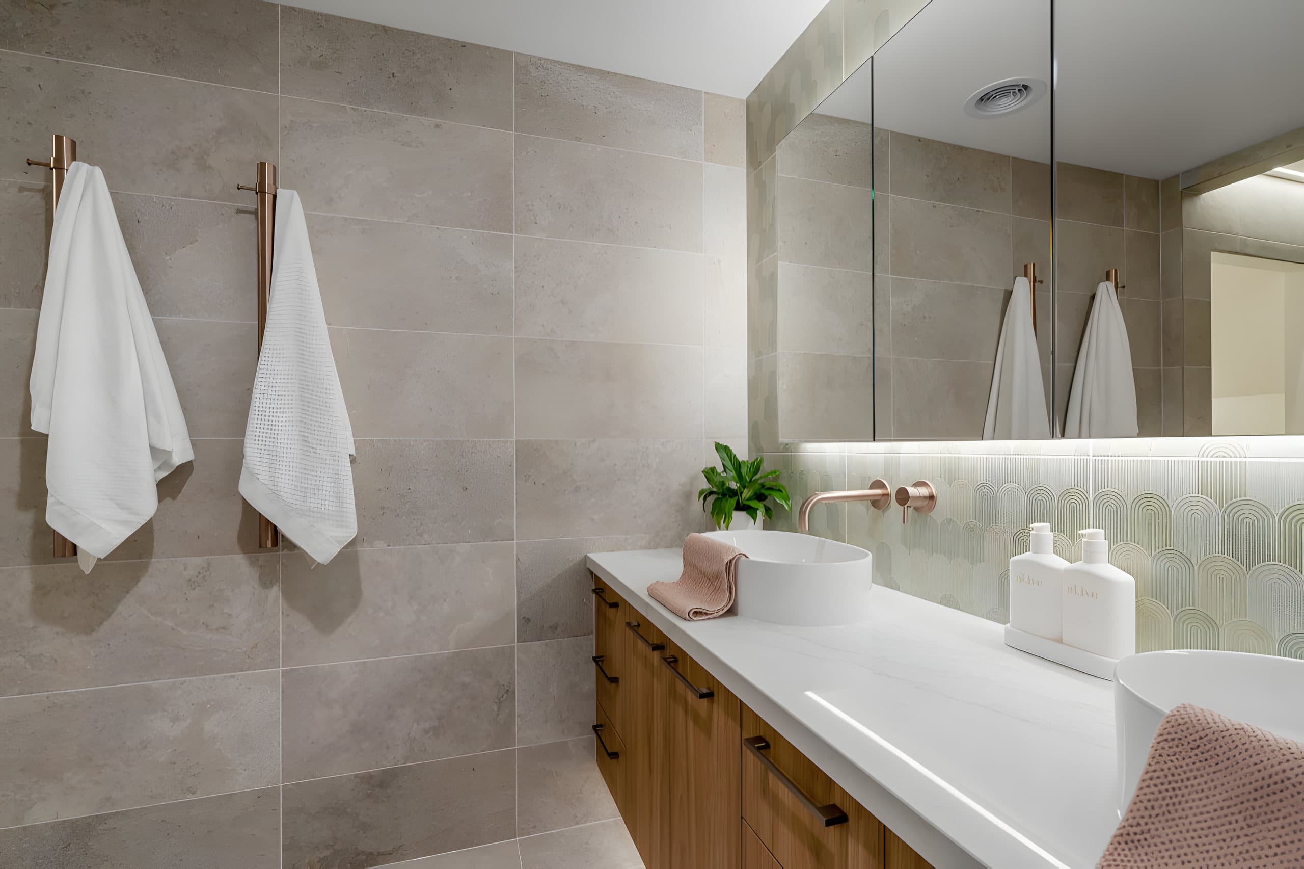 Twin basins on a stone benchtop with green feature tiles