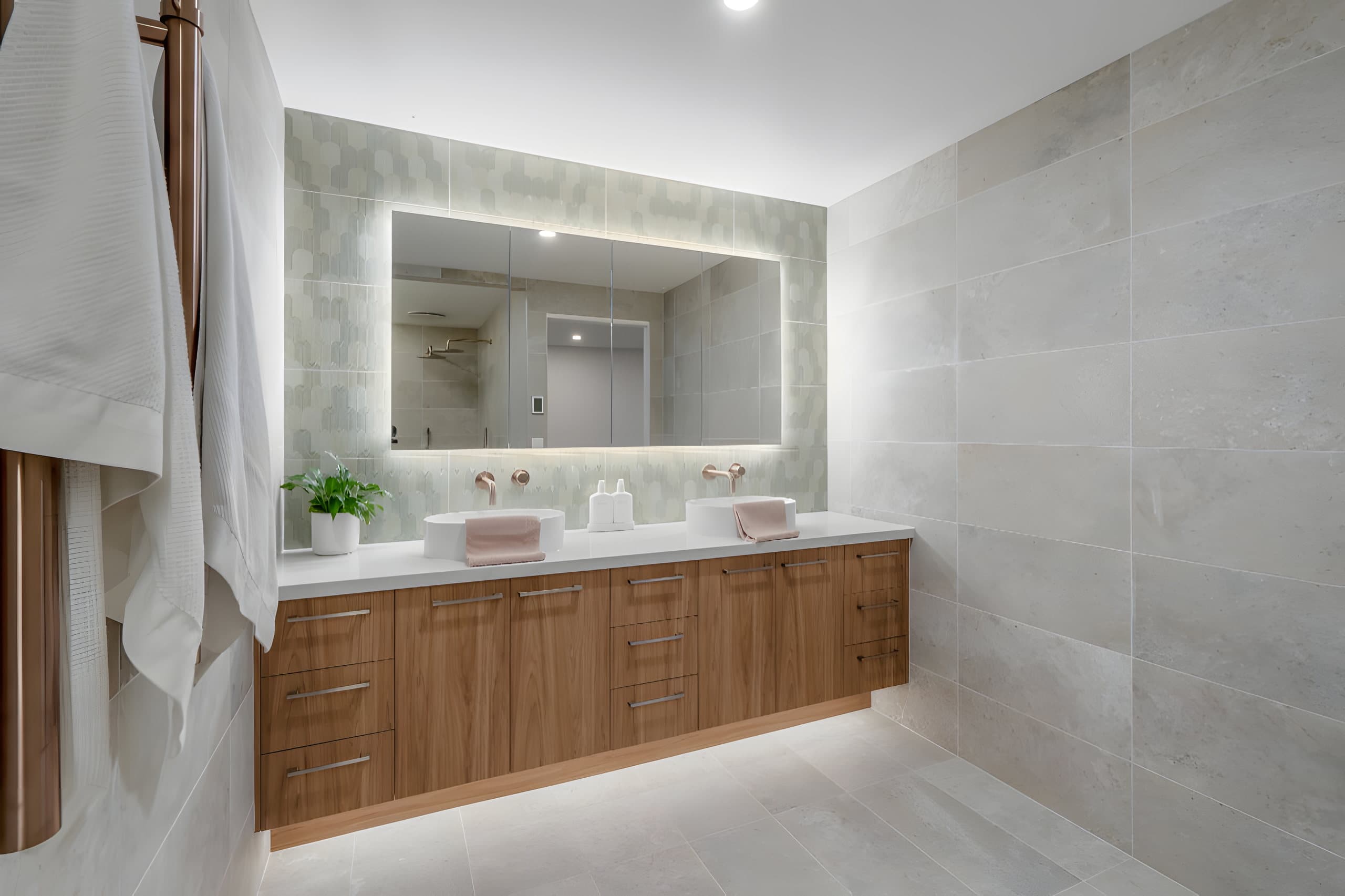 Double vanity with timber cabinets and backlit mirror