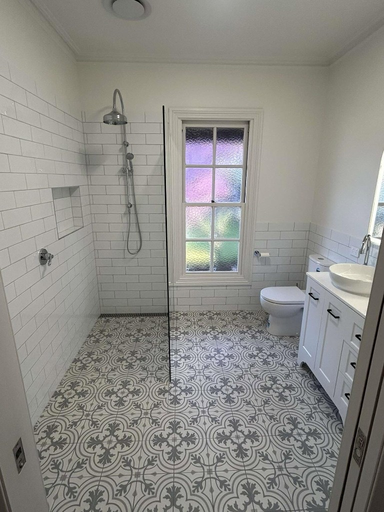 Walk-in shower with patterned floor tiles
