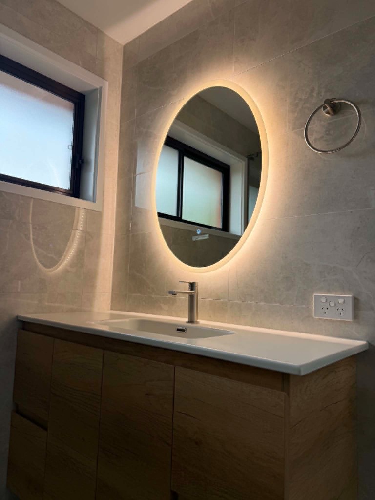 Vanity with backlit oval mirror