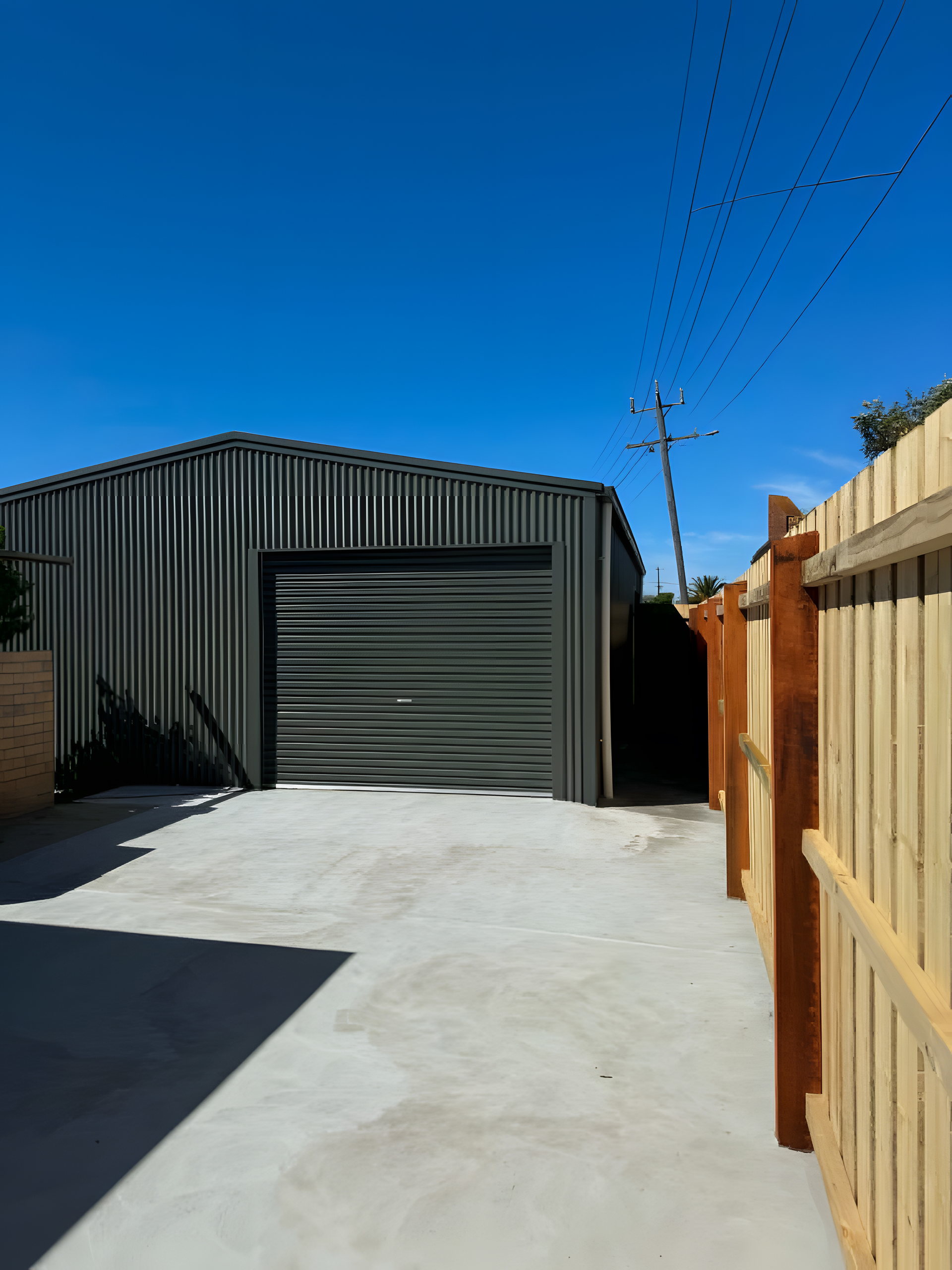 Dark steel shed and new timber fence